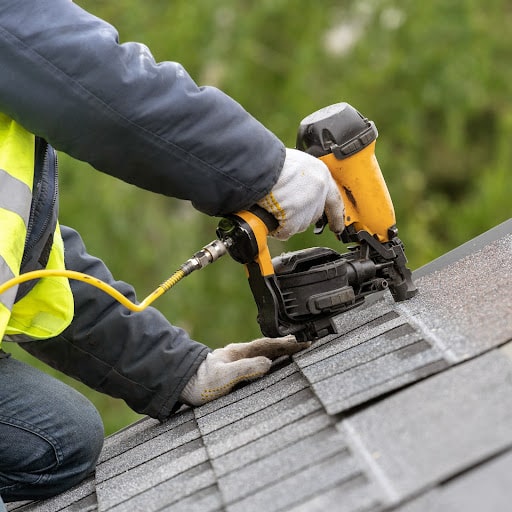  Roofer installs shingles.